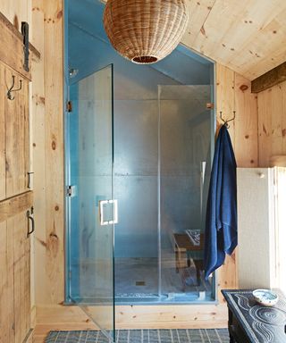 bathroom with pine cladding, shower area with riveted aluminium sheets and rattan lampshade