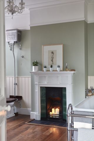 bathroom with fireplace tiles and wooden floor with traditional toilet and bath