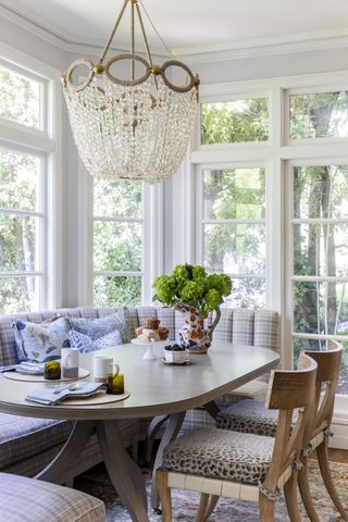 dining table with bench seats all round a bay window with wooden chairs