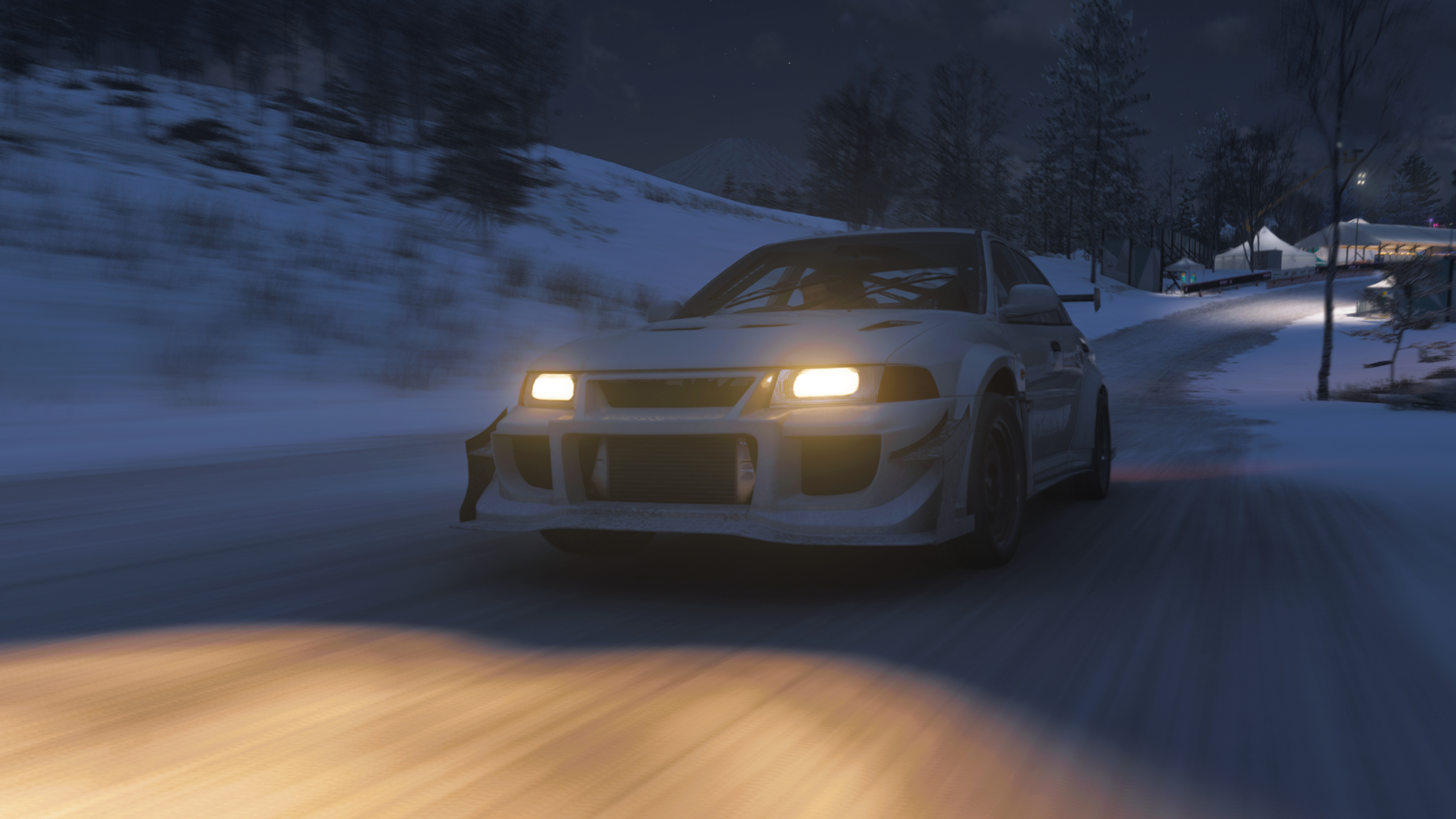 Forza Horizon 6 Festival Loop: A Mitsubishi Lancer Evolution driving down the speed zone towards the camera at night.