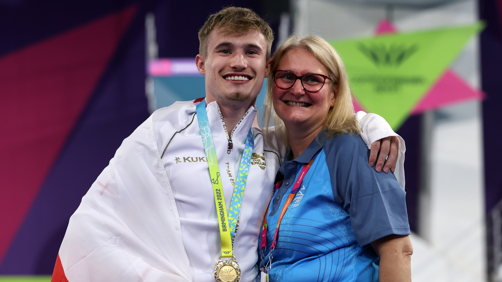 Jack Laugher with his 1m springboard gold medal on the podium with his mother.