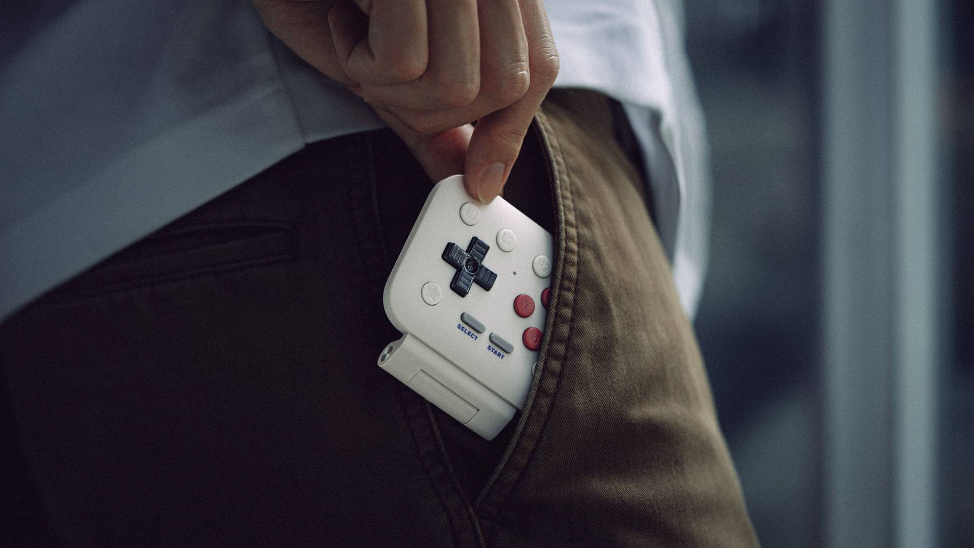 Hand sliding 8Bitdo FlipPad into pocket.