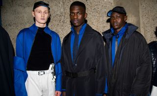 Three male models wearing clothing by Cottweiler in shades of blue.
