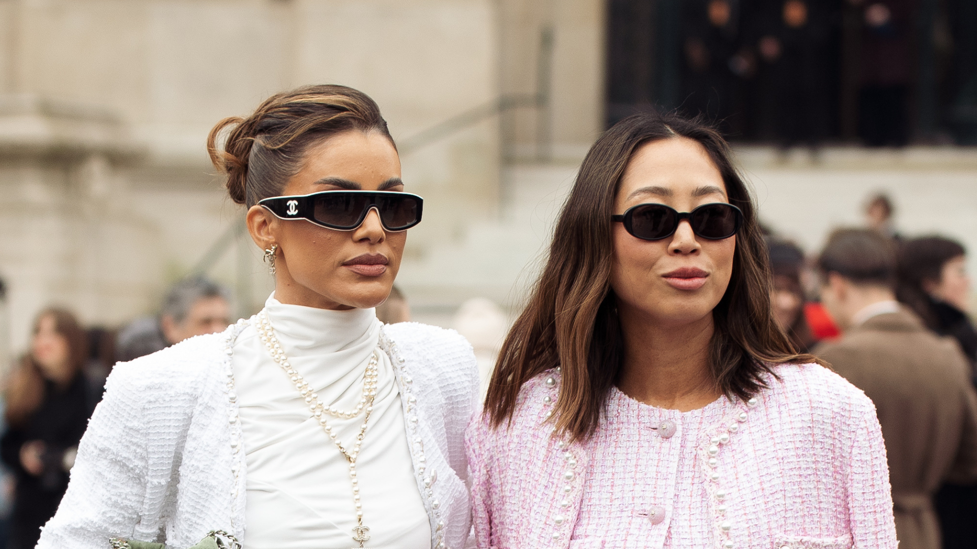 Camila Coelho wears mint green jeans, white turtleneck cropped top, white jacket, green bag and sunglasses and Aimee Song wears blue jeans, pink jacket and beige bag outside the Chanel fashion show during the Womenswear Fall/Winter 2025/2026 as part of Paris Fashion Week on March 11, 2025 in Paris, France