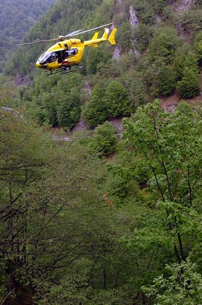 A helicopter lowers a rescue worker into the ravine where Pedro Horrillo crashed during stage eight.