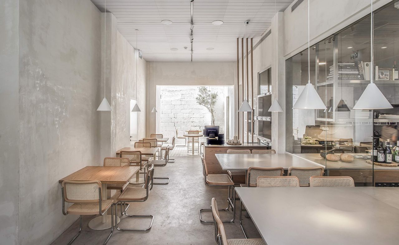 Restaurant interior with wicker seating &amp; large windows