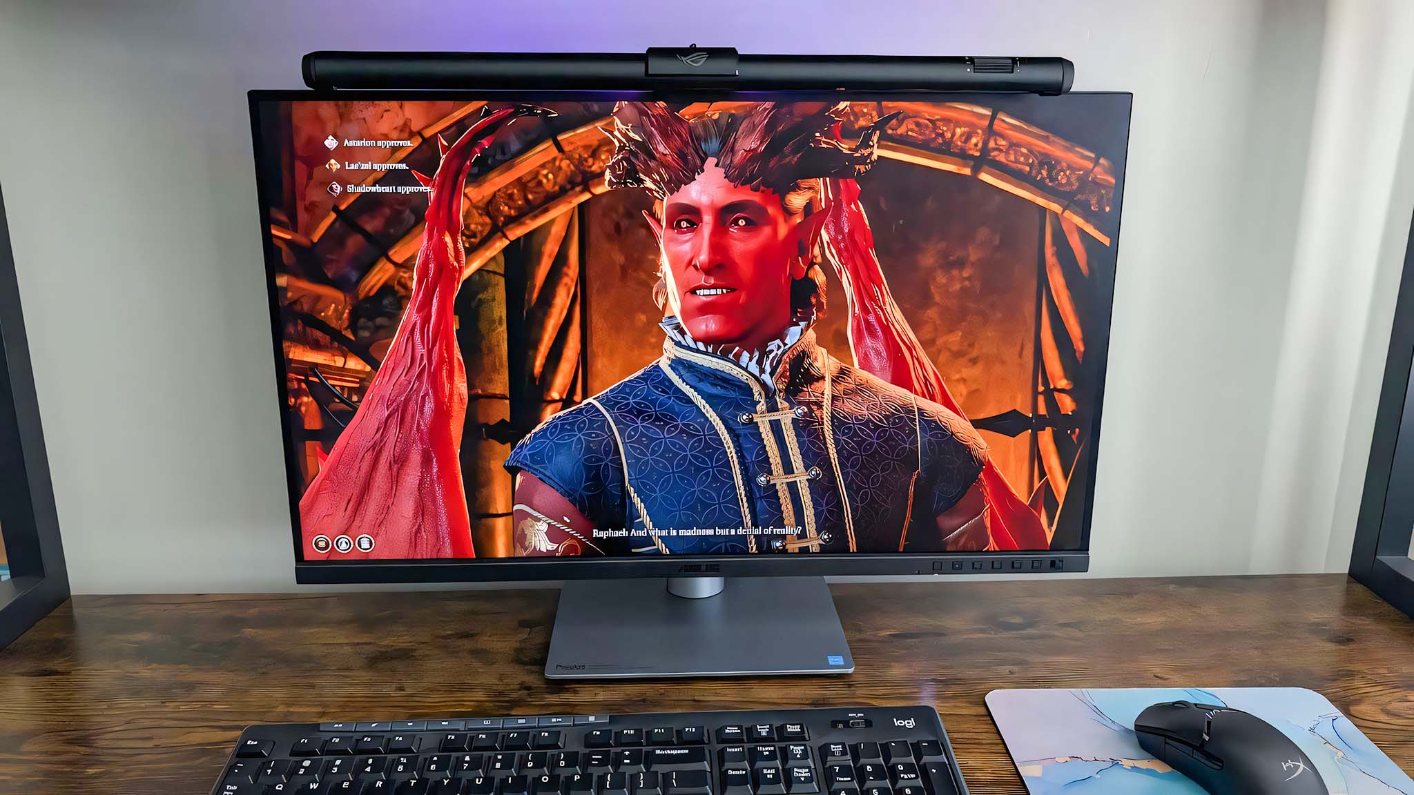 ASUS ROG Aura Monitor Light Bar on a monitor in midday with faint purple RGB showing up on the wall behind the monitor. Baldur's Gate 3's Raphael is on the screen.
