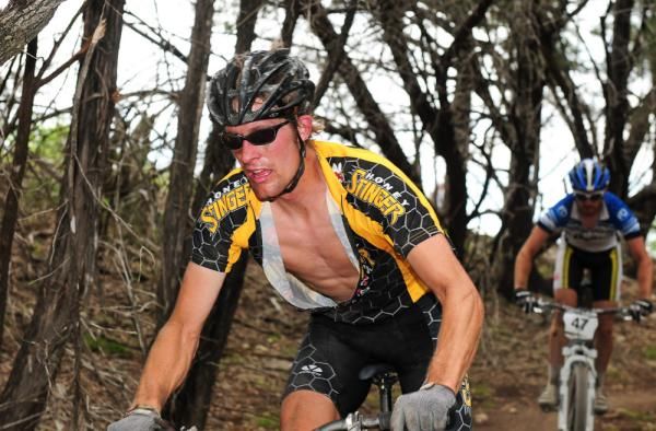 A Honey-Stinger rider descends through some trees.