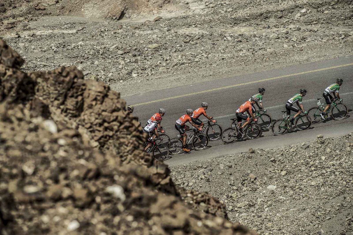 The team ride through the arid landscapes of Oman close behind the Spanish Caja Rural team