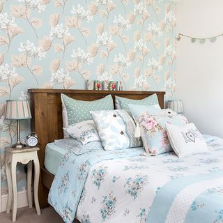 bedroom with wallpaper and pillows on bed