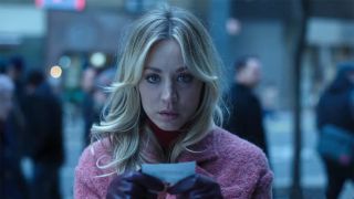 Kaley Cuoco looking at clues in a pink coat during The Flight Attendant. 