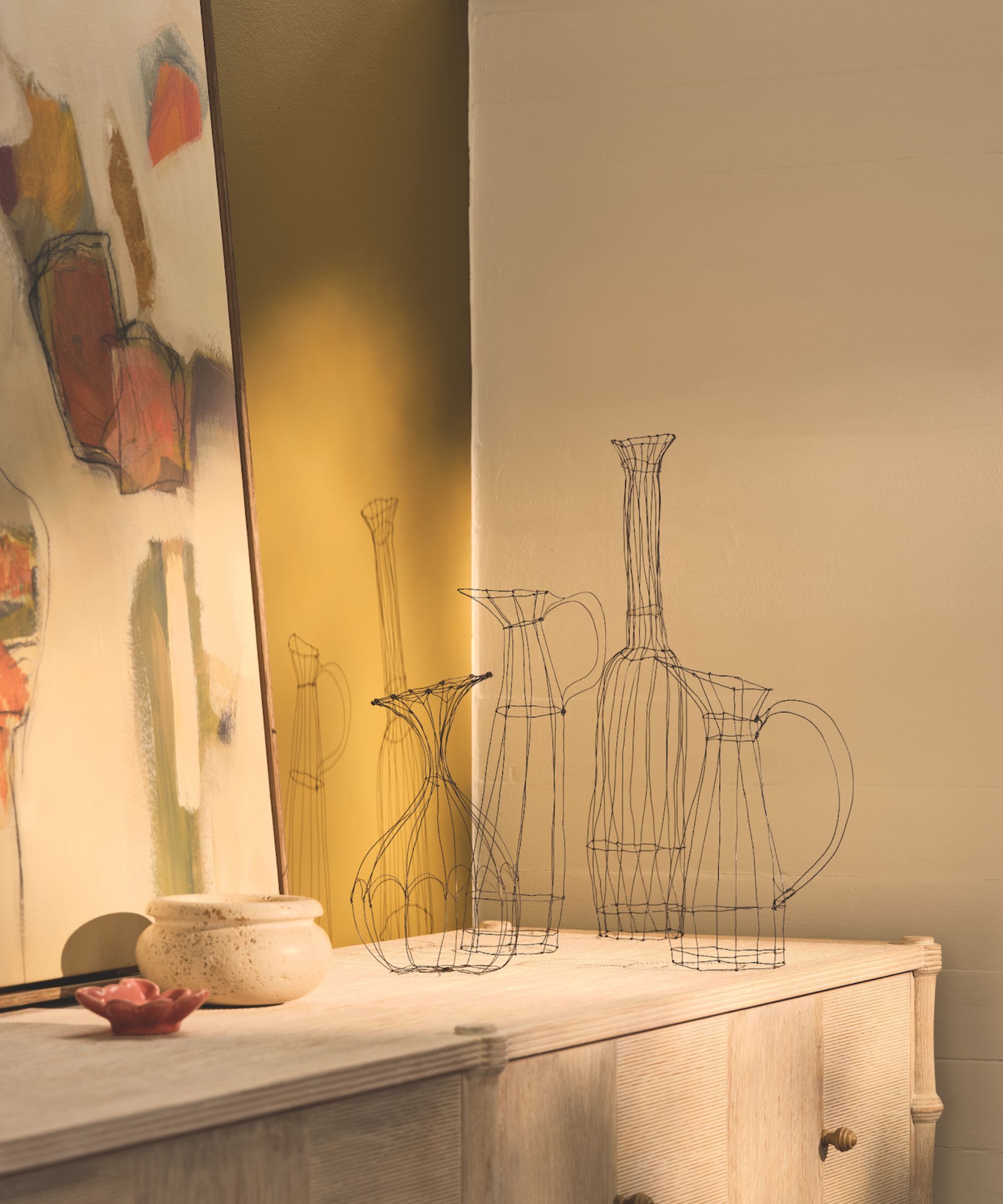 Handmade jug shaped wire sculptures on a sideboard