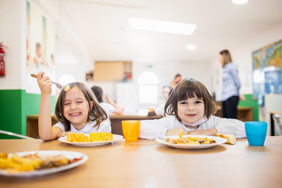  Children sat at a table eating a school dinner 