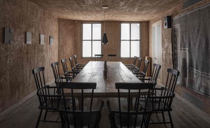 The 16-seat table at Mãos restaurant, London, UK - a large wooden table and chairs in a room with concrete walls