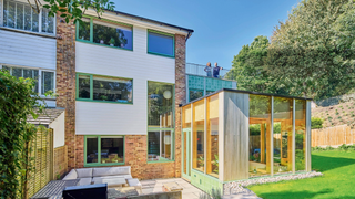 Exterior of the back of the house, showing the side extension, garden and patio area
