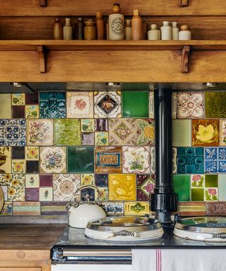 Colourful mismatched wall tiles as a splashback behind an Aga.