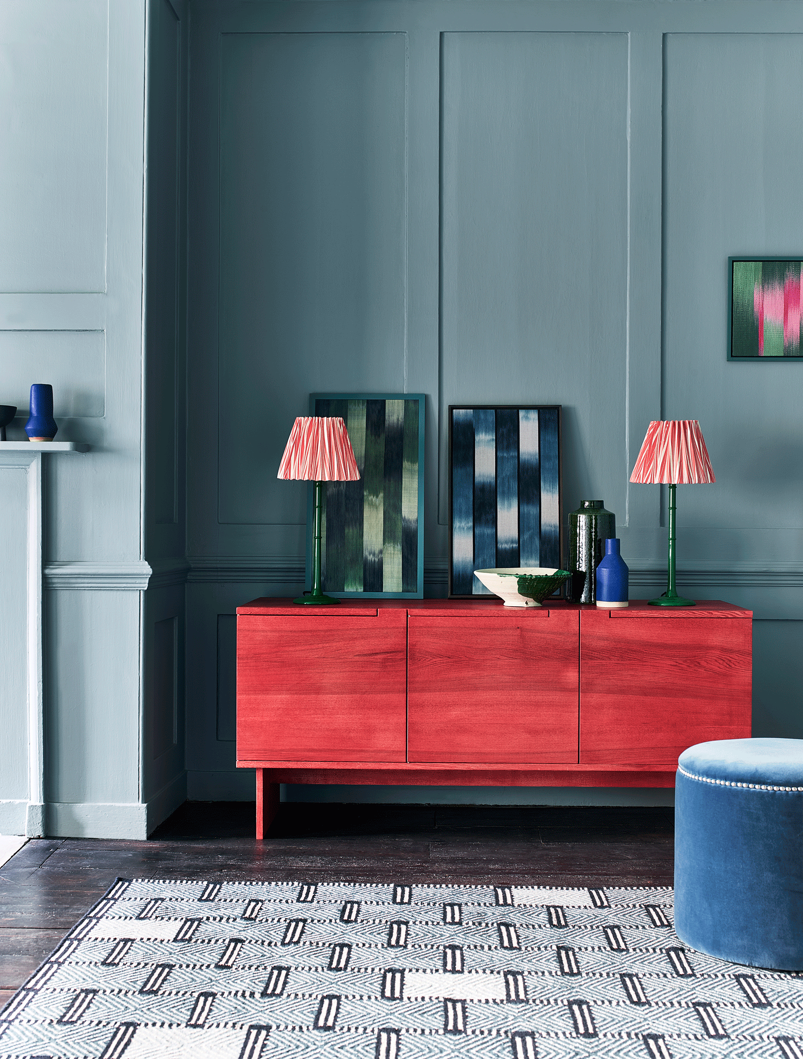 Living room with bold blue walls and red sideboard