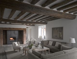 a living room with original features including beams and a fireplace
