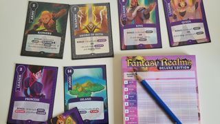 The cards and scoring system of Fantasy Realms Deluxe on a plain table