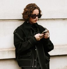 woman dressed in all black shopping on her phone