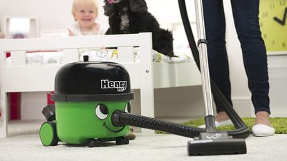 Image of Henry Hoover vacuum in promotional image being used on white carpet 