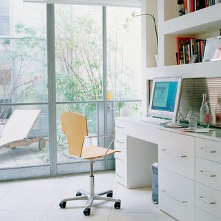 home office work space with self and white drawers
