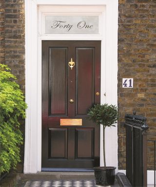 Front door furniture made of brass with narrow kick plate at foot of door