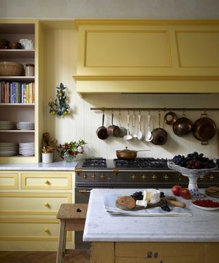 How to organize a kitchen in a scheme with yellow cabinetry and a vintage stove.