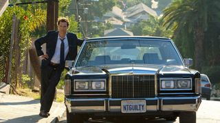 Matthew McConaughey leans on a car in The Lincoln Lawyer movie