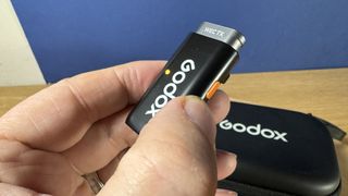 Godox WEC microphone held between two fingers