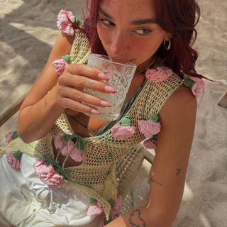 dua lipa wears a crochet top with carnation flowers and a metallic bikini