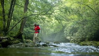 Backpacker hiking across a river in the great smoky mountains national park