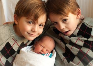 Twin boys with newborn baby.