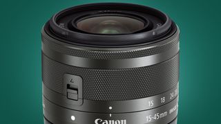 The Canon EF-M 18-45mm lens on a green background