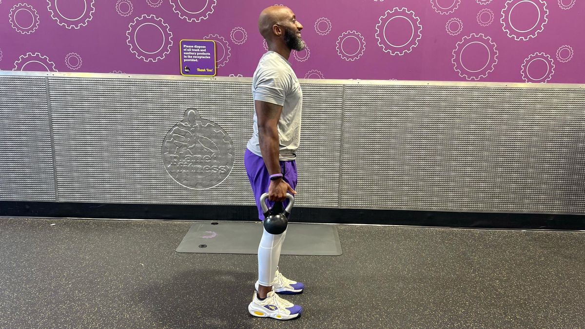 Teddy Savage starting an alternating reverse lunge to overhead shoulder press