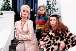 three women in elaborate coats and sweaters sitting on the front stoop of a flat in Absolutely Fabulous