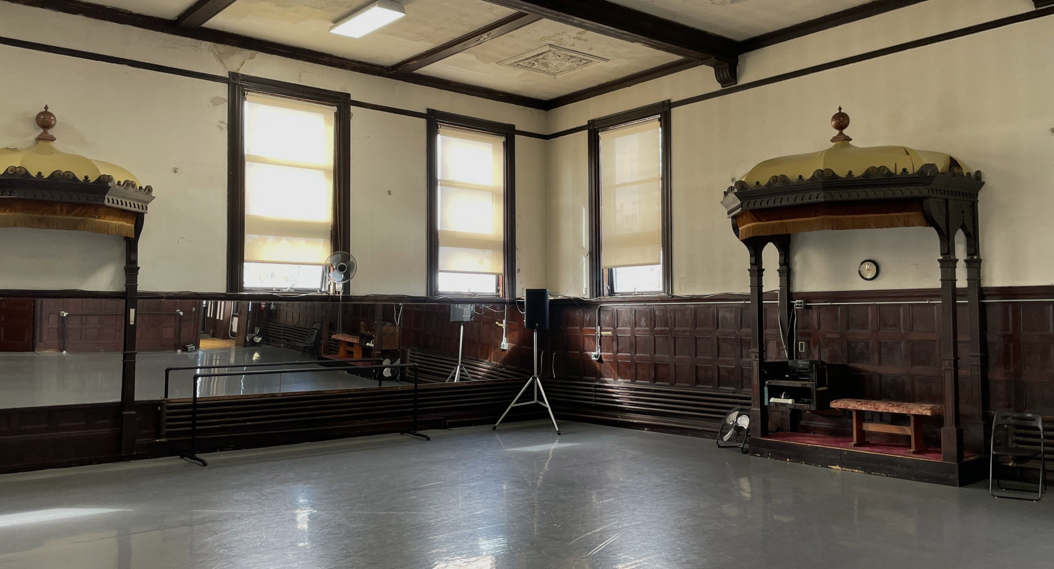 A series of interior shots of an art and objects-filled, dimly lit apartment, a museum's gallery rooms, an empty dance rehearsal room, and colorfully decorated office spaces.