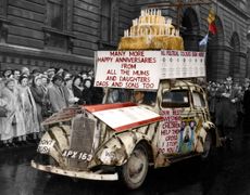 Bearing a huge model cake as greeting for Winston Churchill this car appeared at Downing Street as big crowds gathered to welcome him on his return from the State Opening of Parliament and ceremonies marking his 80th Birthday.