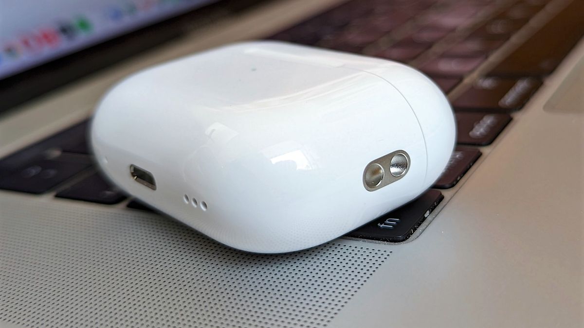 Apple AirPods Pro 2 charging case placed on MacBook keyboard 