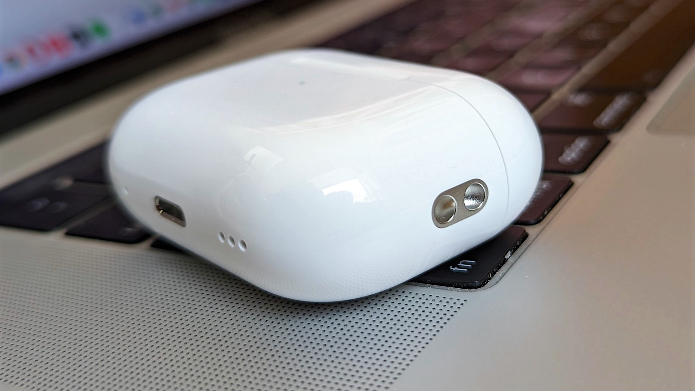 Apple AirPods Pro 2 charging case placed on MacBook keyboard