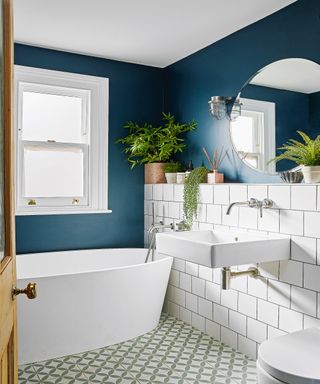 Dark blue painted bathroom walls alongside crisp white contemporary sanitaryware