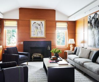 Black fireplace and armchairs, black coffee table, wooden walls