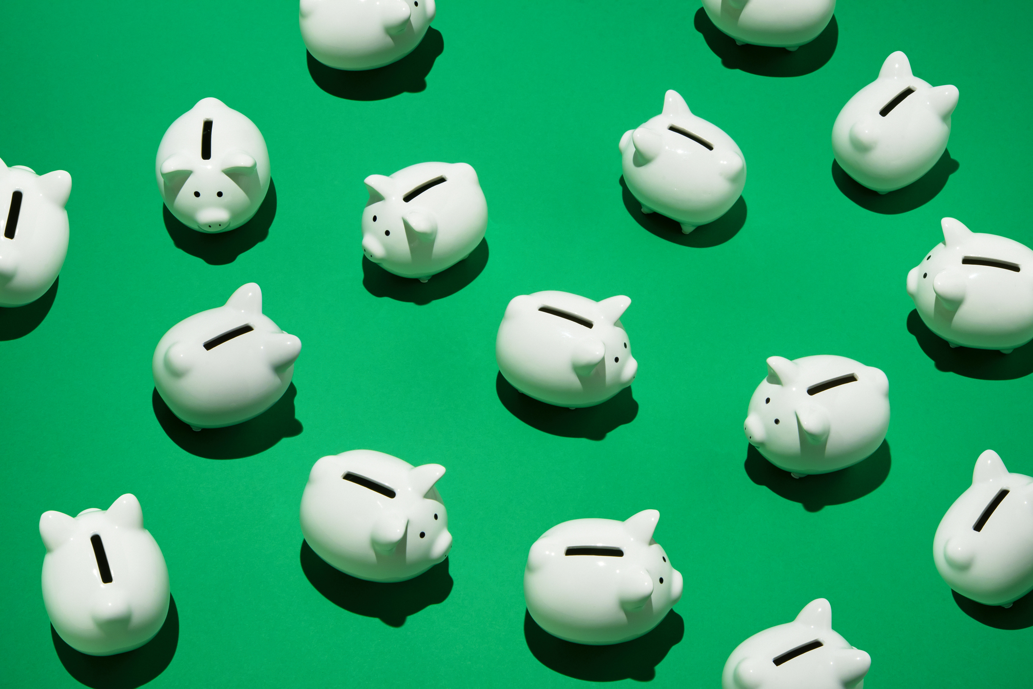 Piggy banks against green background