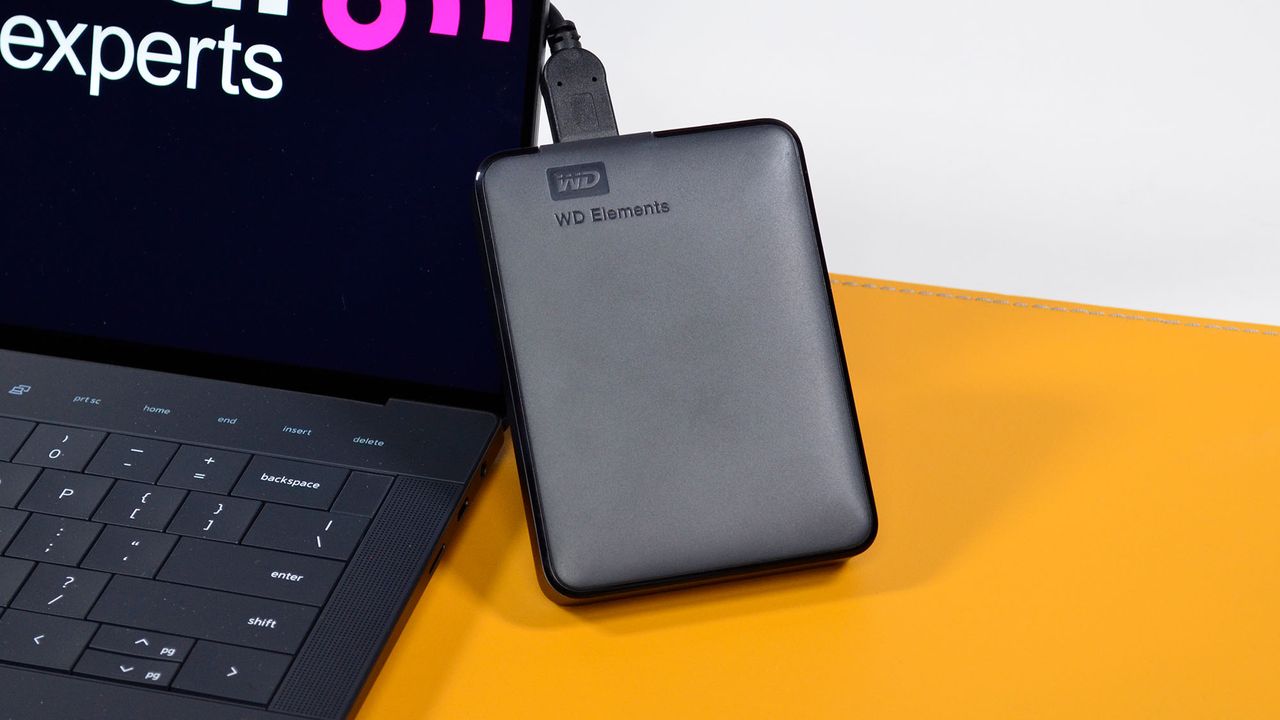 A hand holding a WD Elements external hard drive