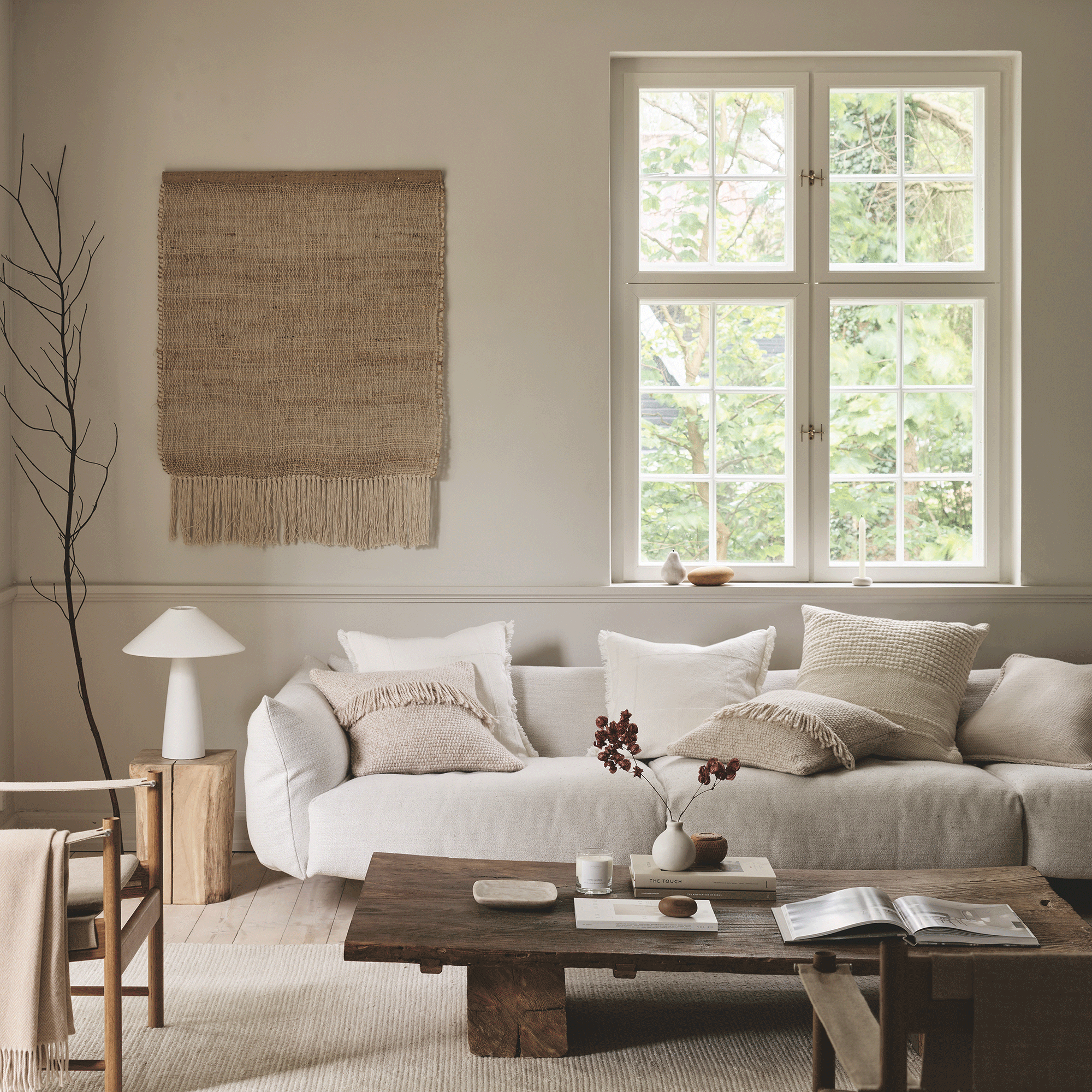 The White Company living room with white sofa, rug on wall and white lamp
