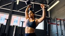 A woman doing single arm dumbbell snatches