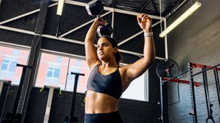 A woman doing single arm dumbbell snatches