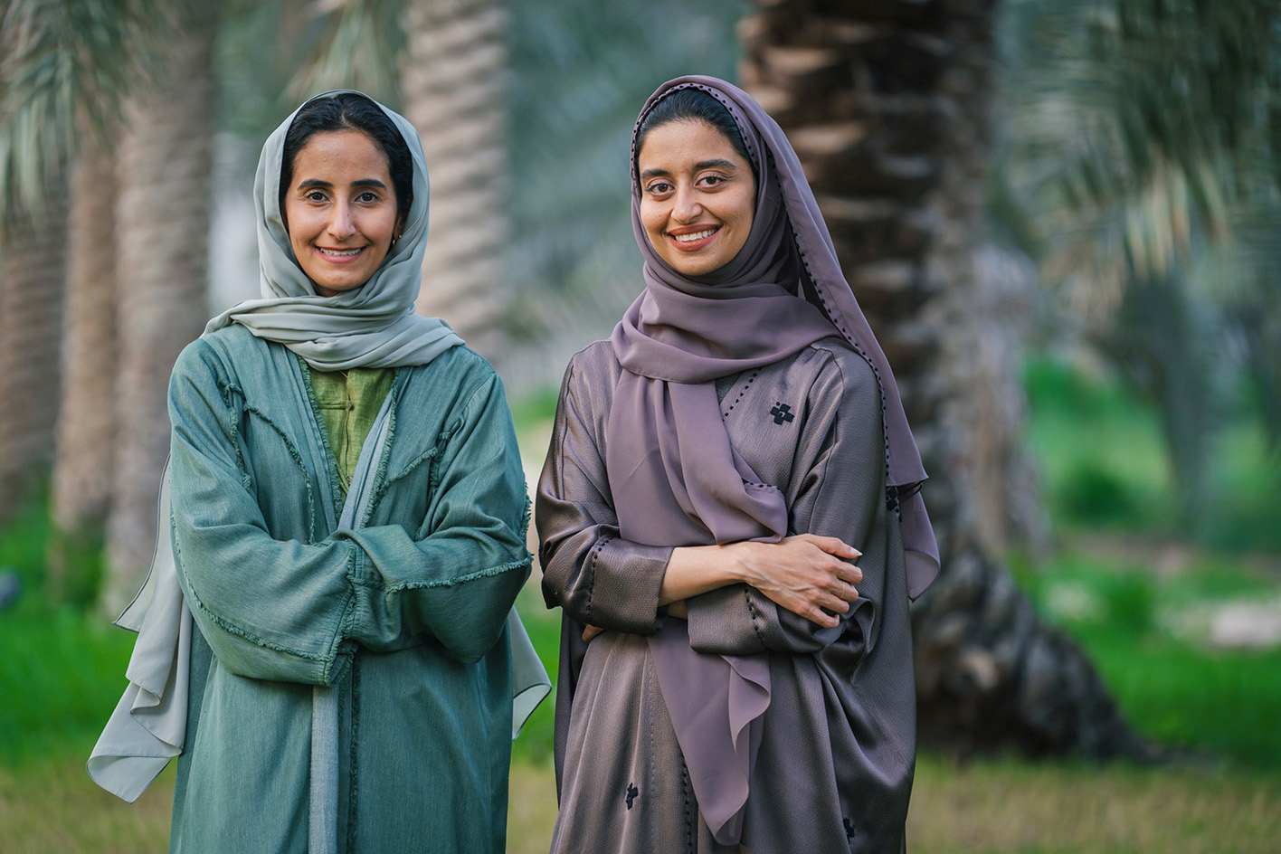two smiling saudi arabian women in modest attire