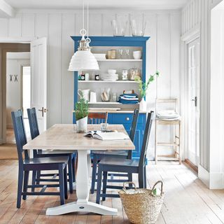 White dining room with blue dresser and table