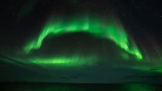 Northern lights above the ocean.